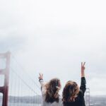 two women making peace sign near the Golden Gate bridge